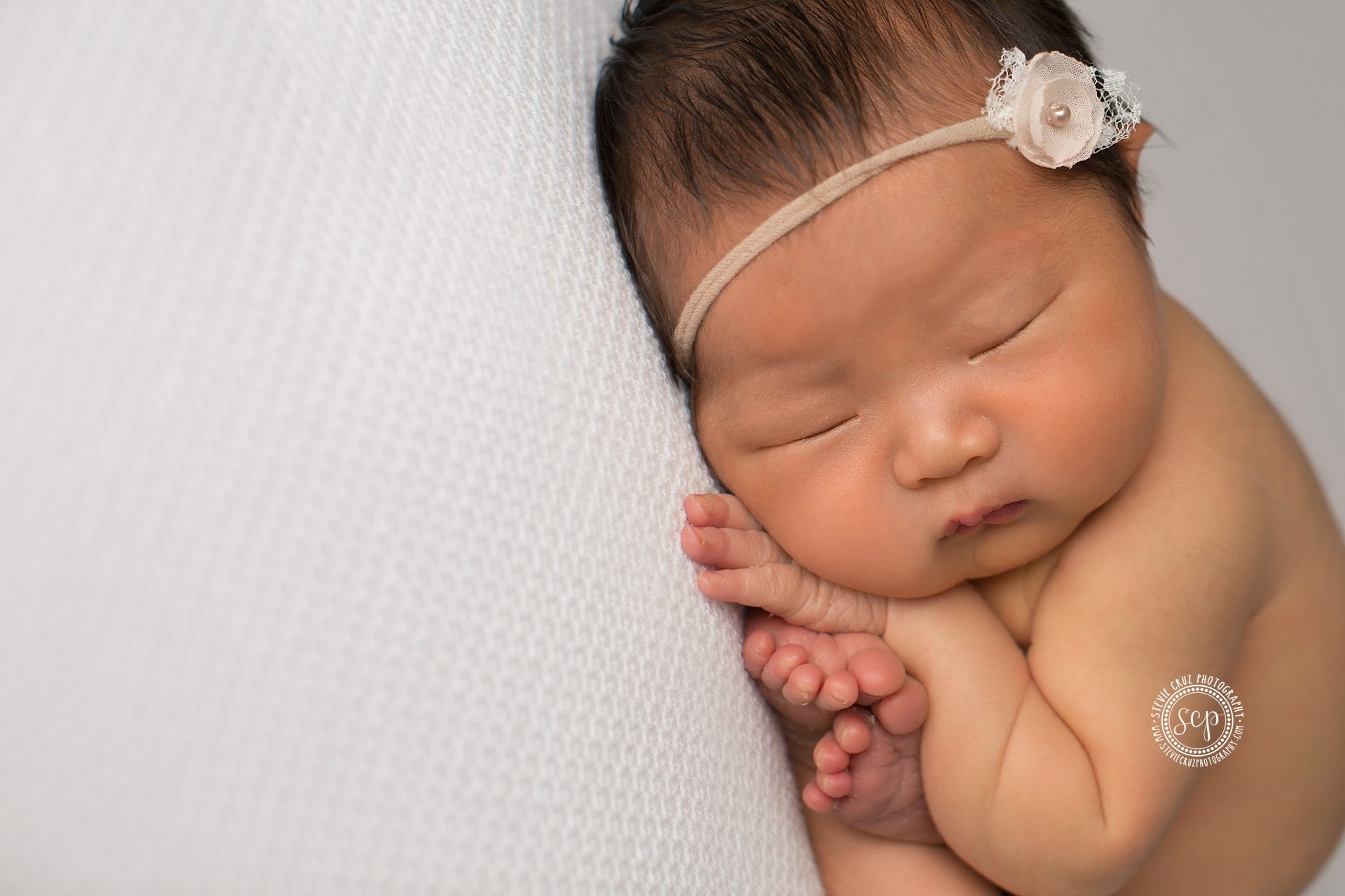 Photo of cute sleeping baby girl during her newborn photo shoot 