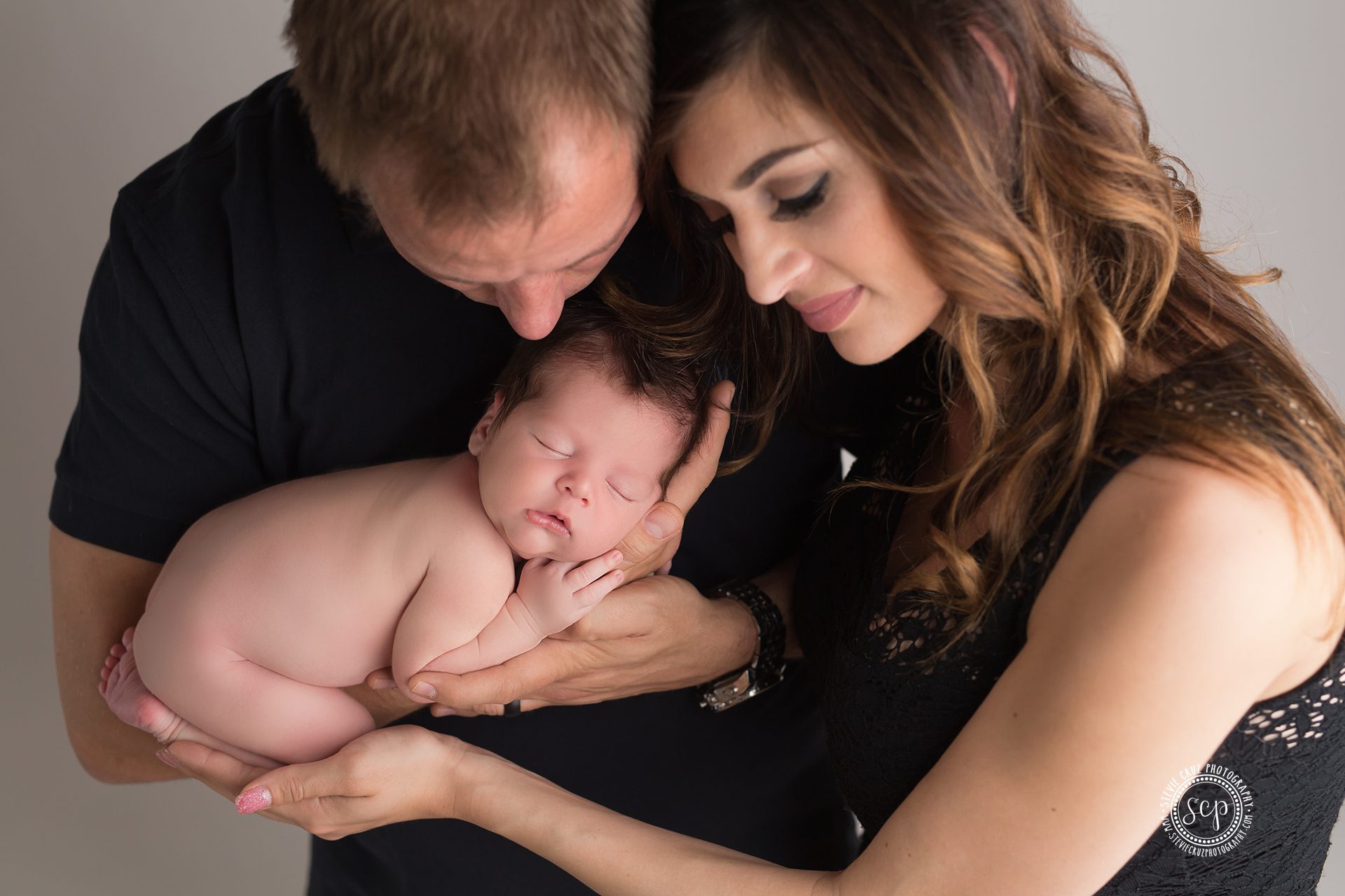 pose ides for parents holding newborn baby boy. Orange County Photo studio 