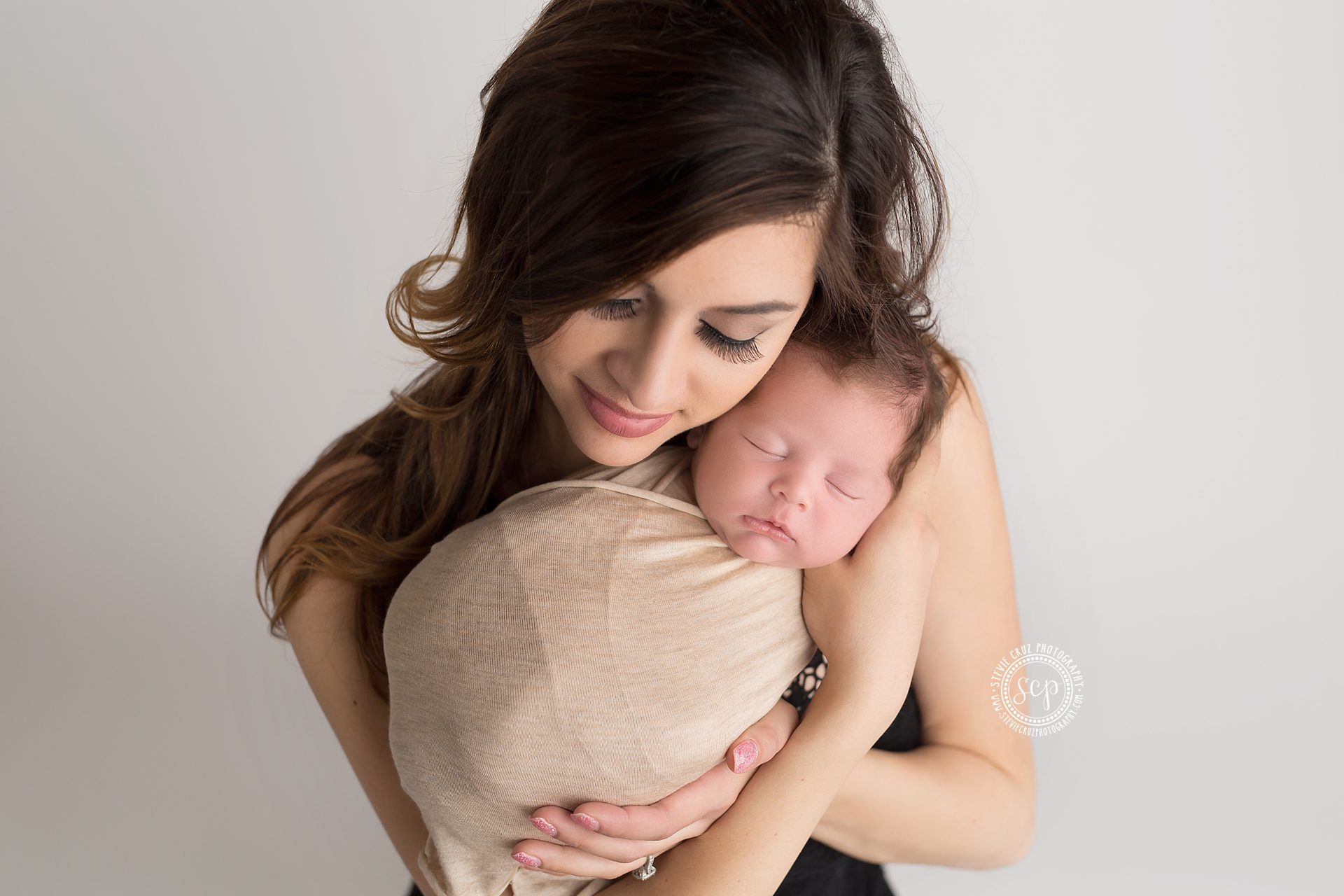 gorgeous new mom holding baby boy for newborn pictures