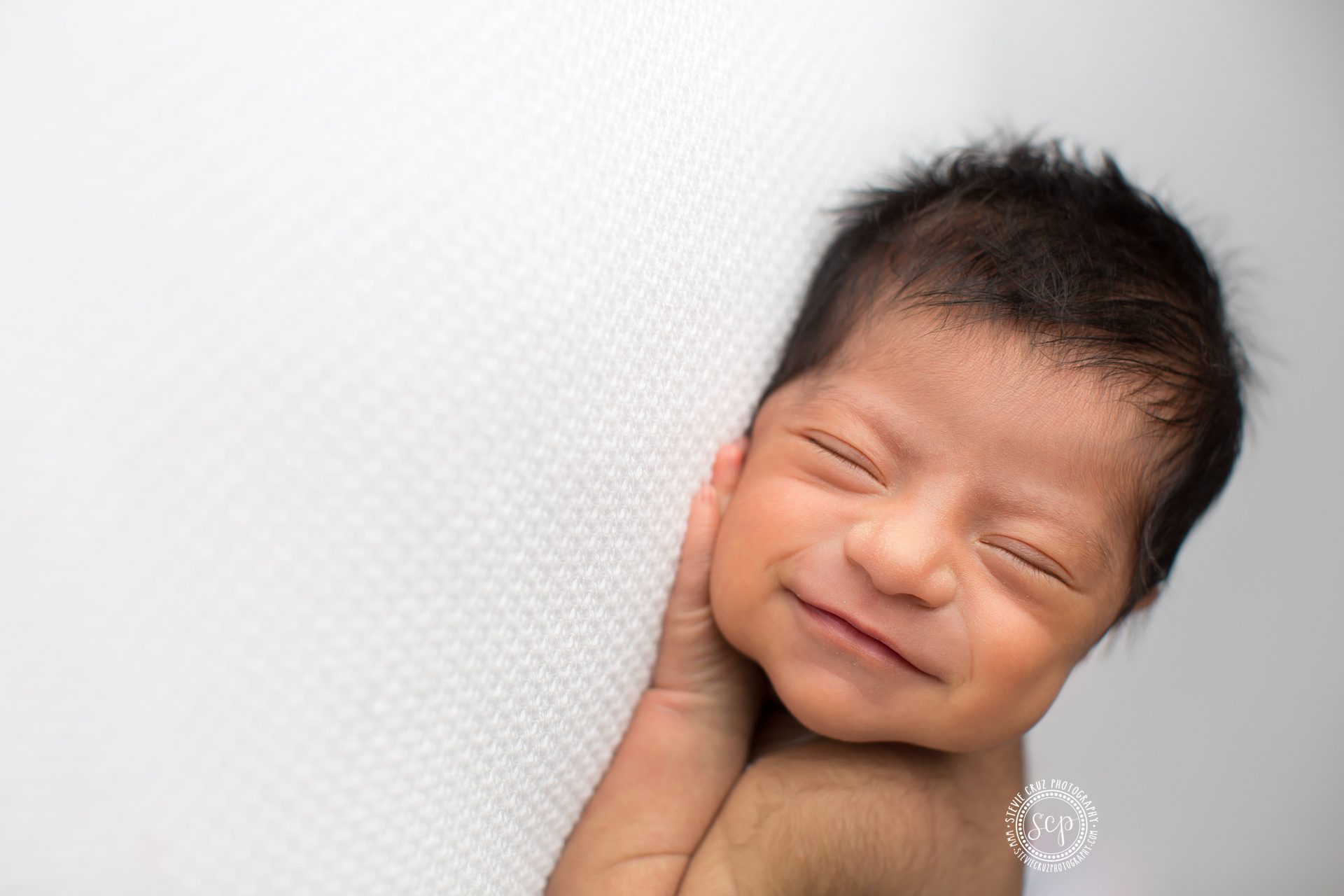 Professional SoCal newborn photographer captures baby girl smiling during her sleep